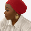 African American woman wearing a red versatile turban headwrap from Aloumbabelle, elegant and stylish, perfect for protective hairstyles and everyday wear.