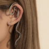 Woman wearing silver snake ear cuff earring wrapping around ear