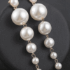 Long cascade pearl drop earrings on black background