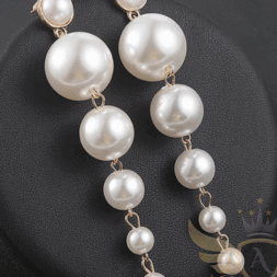 Long cascade pearl drop earrings on black background