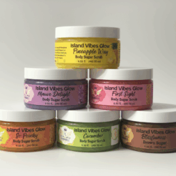 Stacked jars of Aloumbabelle Island Vibes Glow Body Sugar Scrub collection featuring Blissfulness, Pineapple Way, So Peachy, Mauve Delight, Cucumber, and First Sight