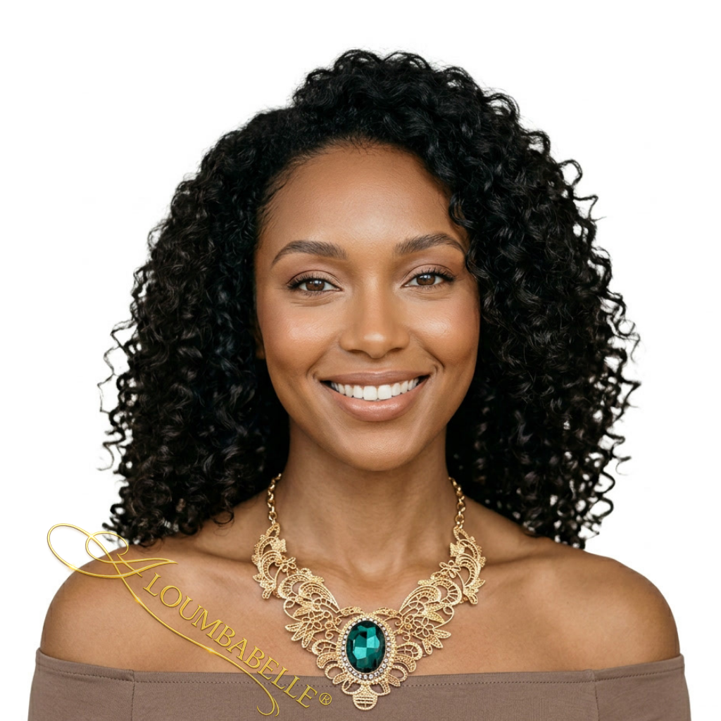 African American woman wearing a luxury gold filigree necklace with emerald green gemstone pendant