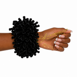 Black volumizer scrunchie worn on a model’s wrist with nude French manicure nails; ALOUMBABELLE visible as protective image branding and MGMAA visible as a protective watermark, not product features